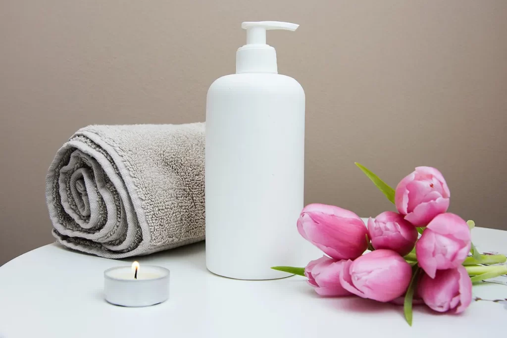 Beauty products and tulips on white table