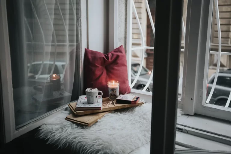 Non toxic candle burning on cozy table by window