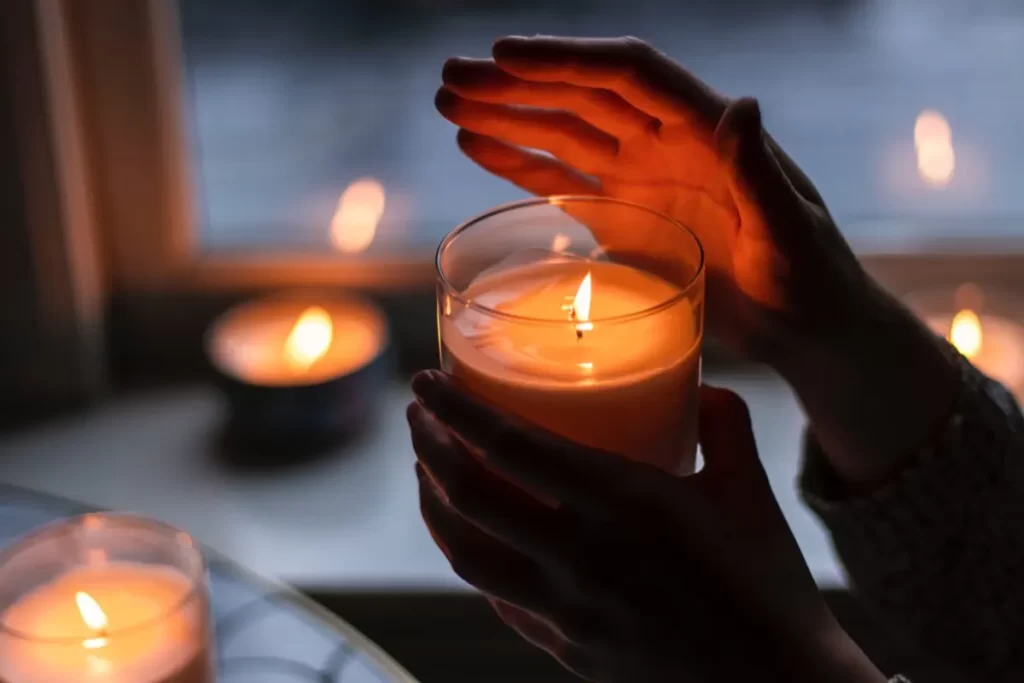 Handing holding glass candle